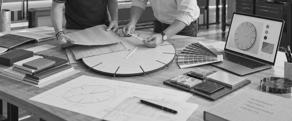 CalleaDesign design consultation with wall clock, material samples and colour references in the Italian atelier