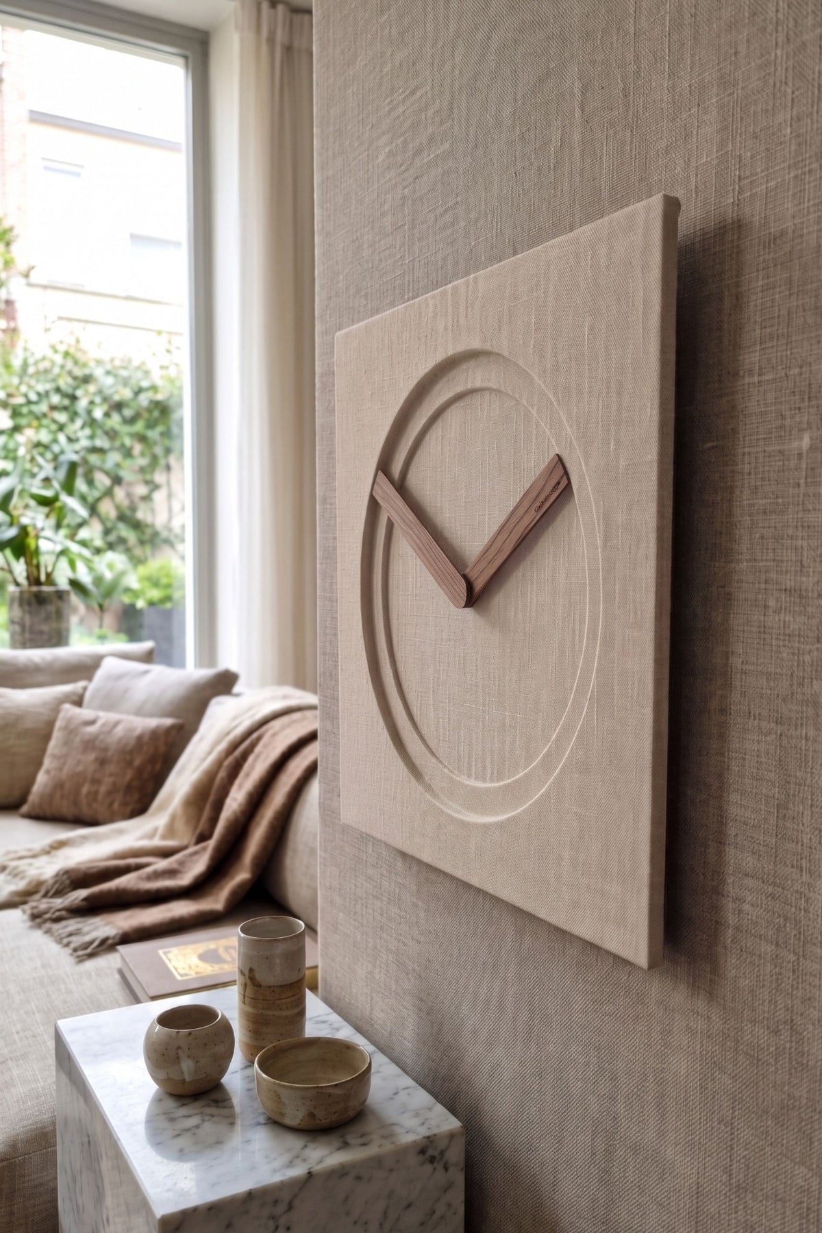 KAM 1 Limited Edition wall clock in natural linen with Canaletto walnut hands in a refined contemporary interior