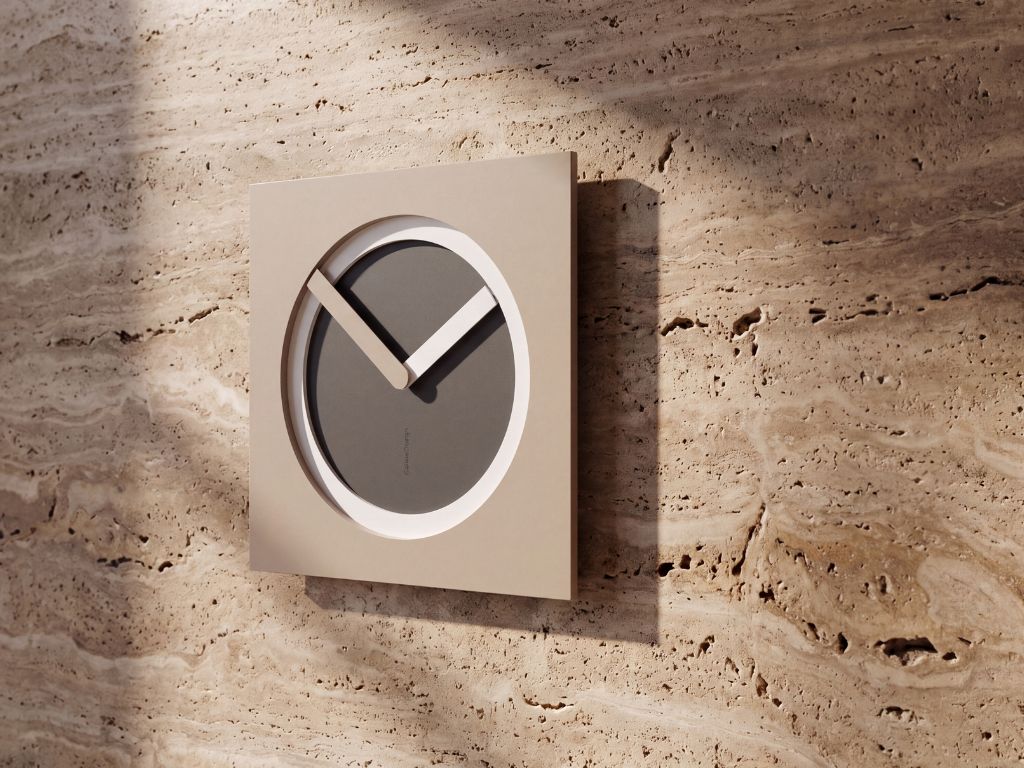 CalleaDesign KAM wall clock with layered geometric design displayed on a travertine wall