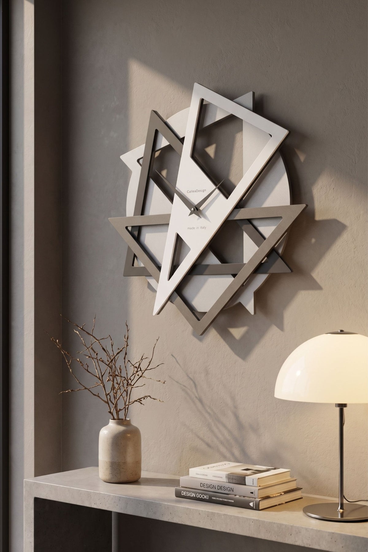 CalleaDesign Geolo wall clock in white and greige finishes on a warm textured wall in a contemporary interior