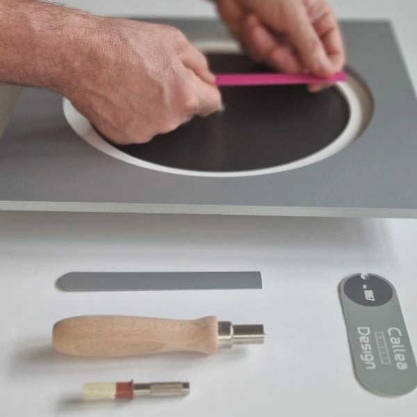 Hands placing the pink clock hand on KAM Bloom during assembly in the Italian atelier
