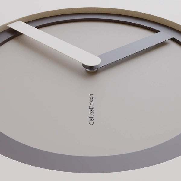Close-up of the KAM Terra wall clock with a warm taupe dial, dark ring and pale hands